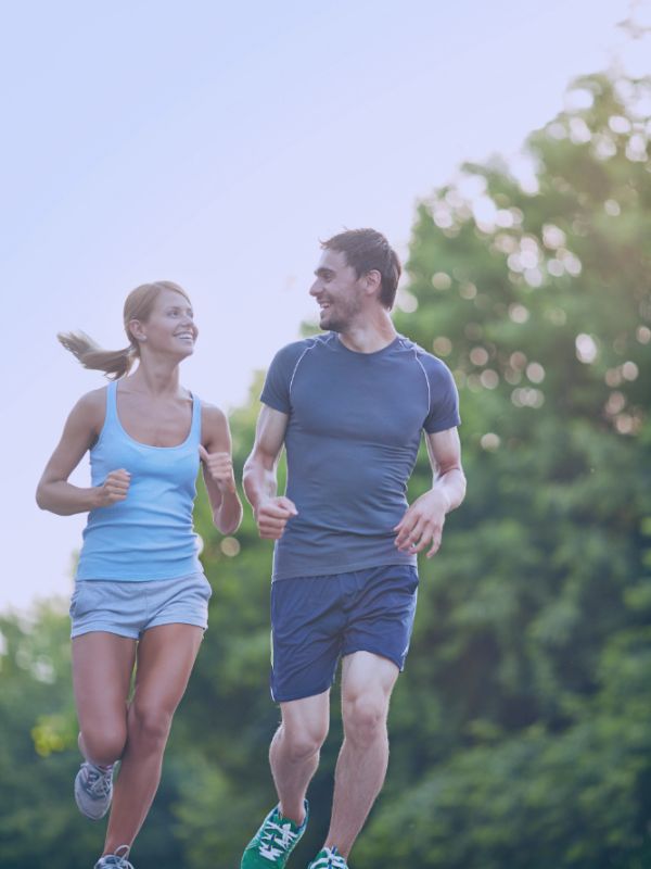 Mujer y hombre corriendo bajo el sol