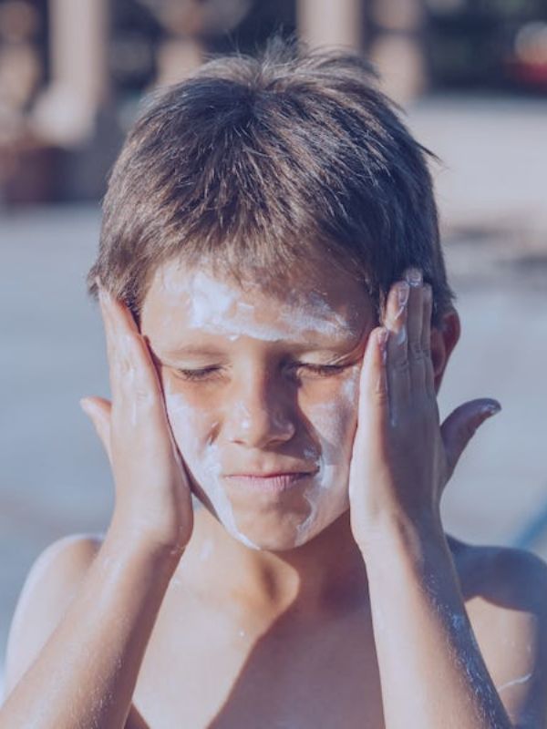 Niño con protector solar en la cara